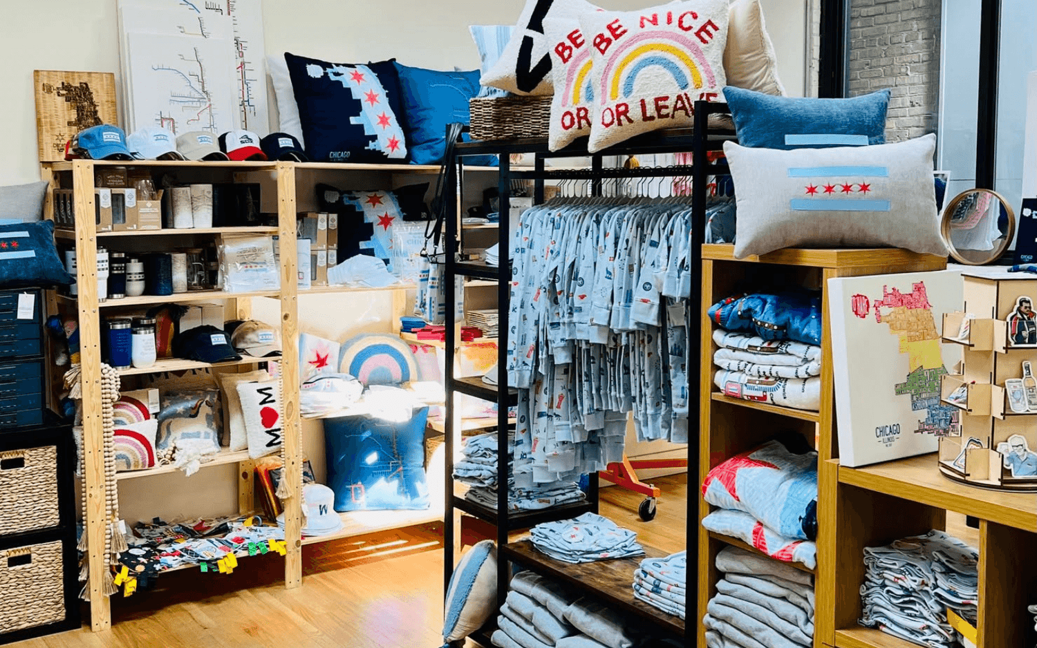 Store display at a craft fair filled with Chicago-themed merchandise: pillows, caps, apparel and homeware.