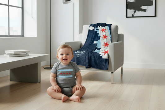 Baby in Chicago flag onesie with blanket in room